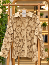 Camisa de Encaje Alfonsina beige en percha, con motivos florales calados y puños lisos.