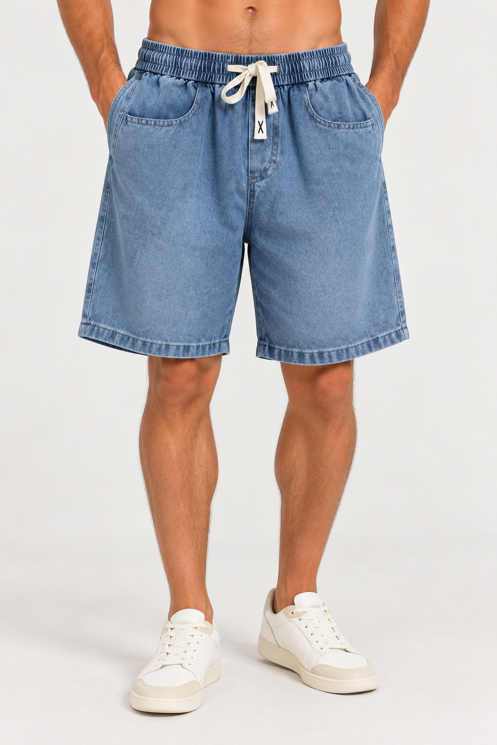 Bermuda de jean Saúl azul lavado, con cintura elastizada, cordón claro, bolsillos delanteros y corte amplio.