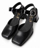 Zapatos Paris en tono claro puestos, con taco ancho y pulsera al tobillo