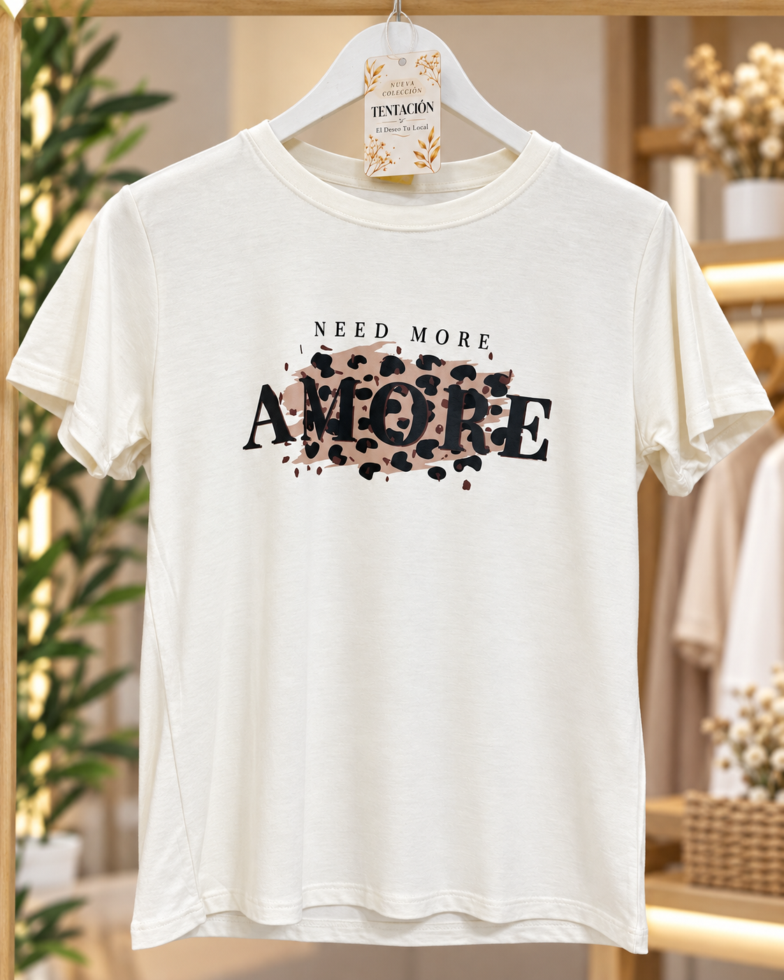 Remera Need More en beige claro, con mangas cortas y estampa frontal NEED MORE AMORE con animal print.