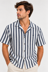 Camisa Rayada Tomás de manga corta con rayas azules y blancas, cuello abierto y botones frontales.