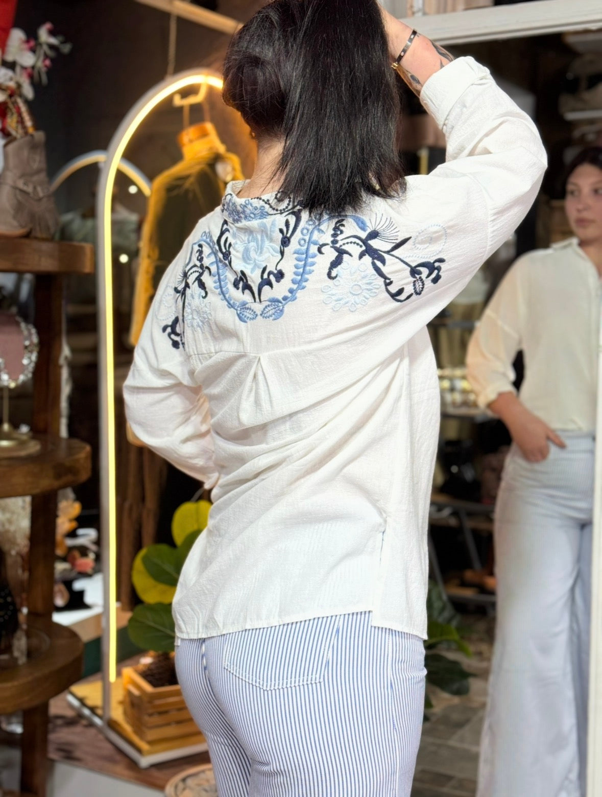 Camisa Artemis blanca bordada combinada con pantalón a rayas